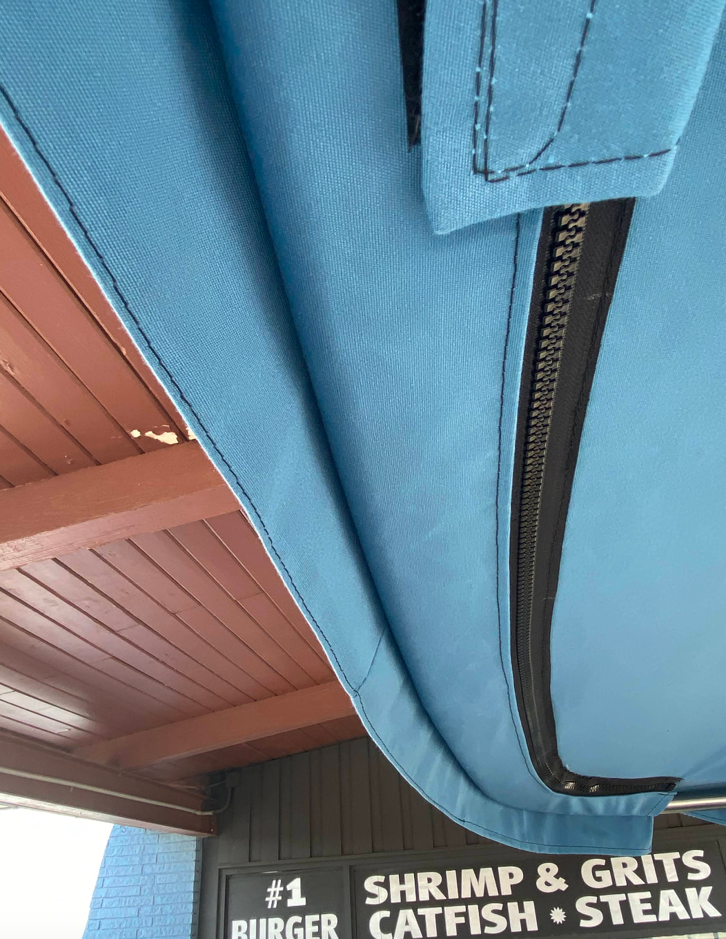 A restaurant with a sign that says shrimp and grits catfish steak