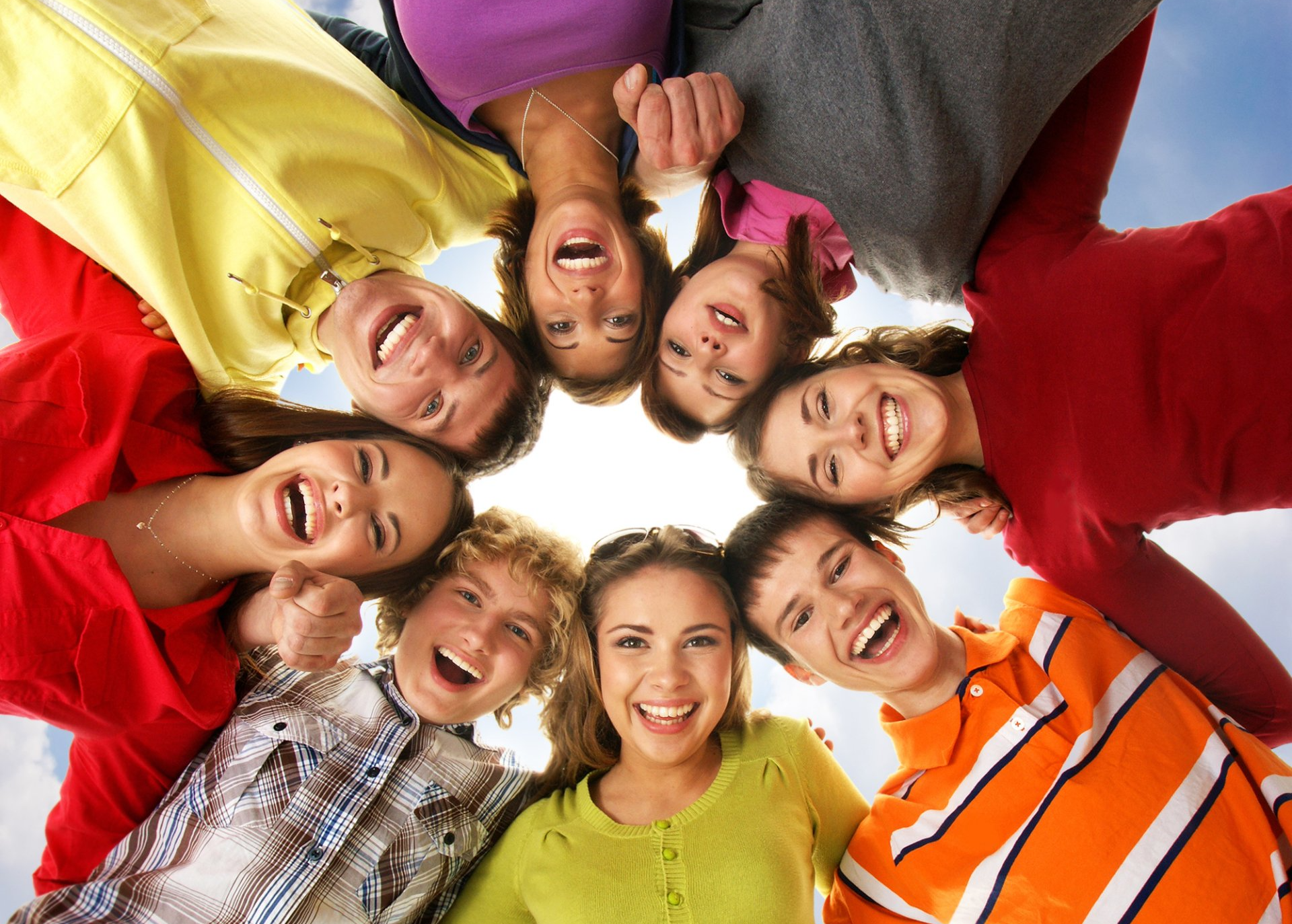 young people in a circle smiling at camera