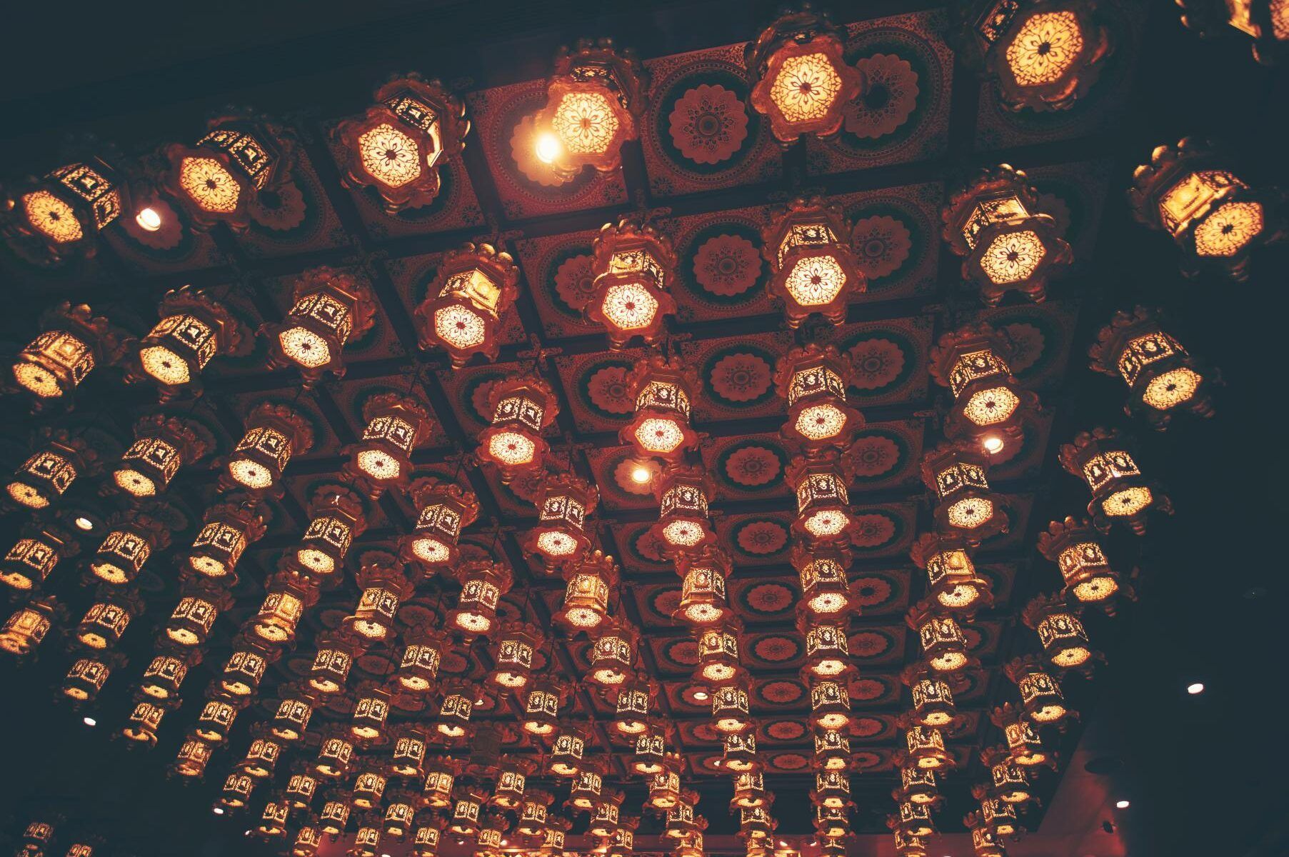 Ceiling adorned with numerous glowing, patterned lanterns.