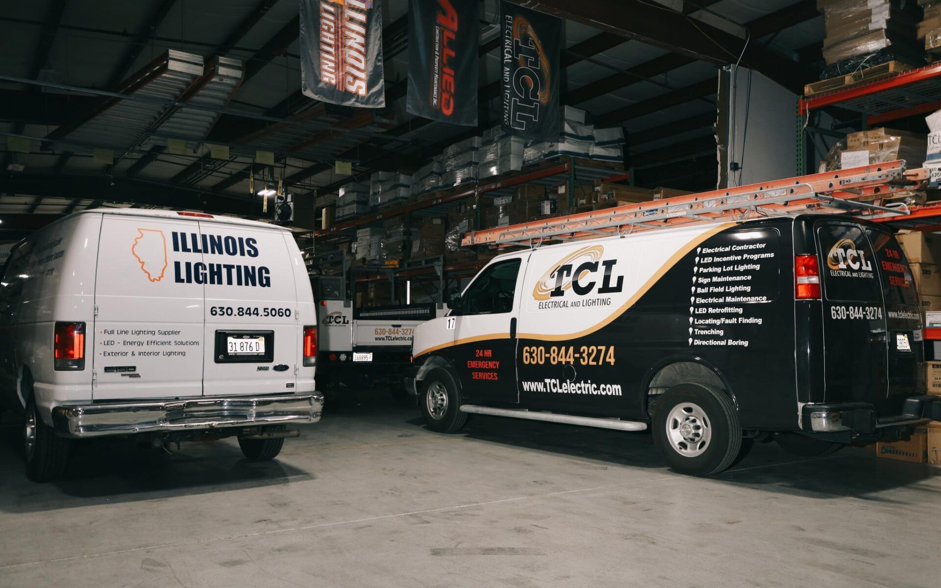 Two service vans parked inside a warehouse; one labeled 