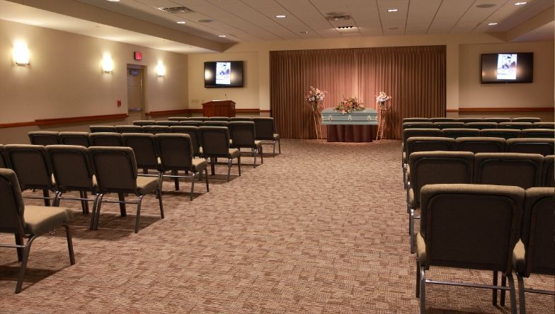 A row of green chairs in a funeral home