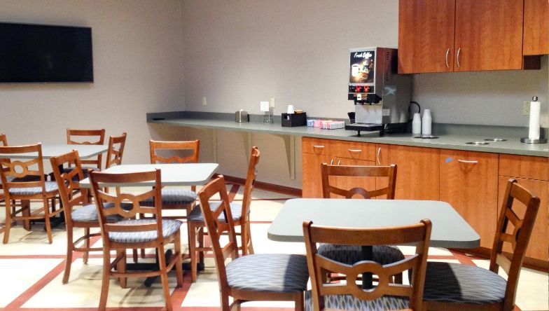 A kitchen with tables and chairs and a refrigerator