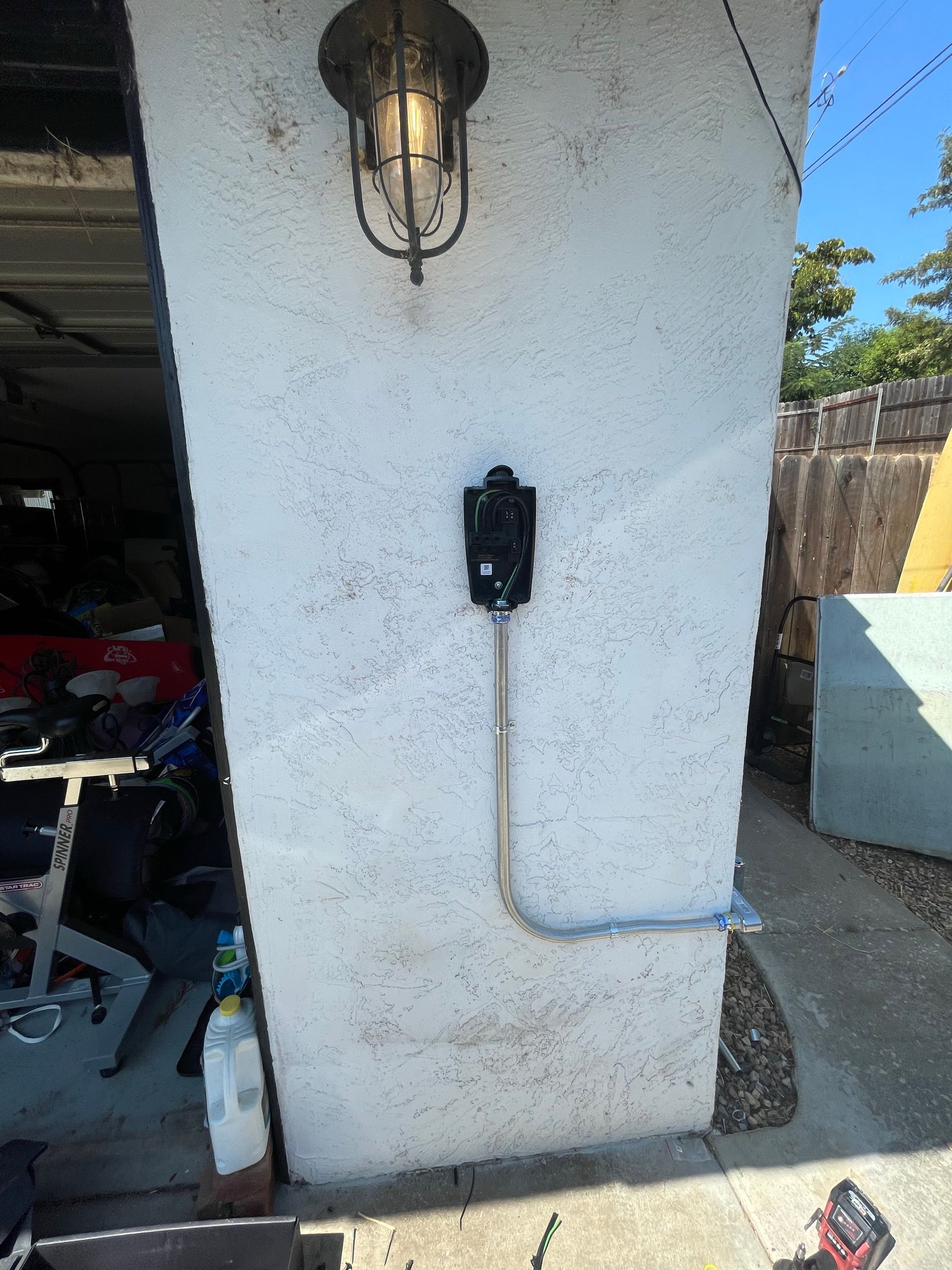 Exterior wall with an electrical outlet, conduit, and light fixture.