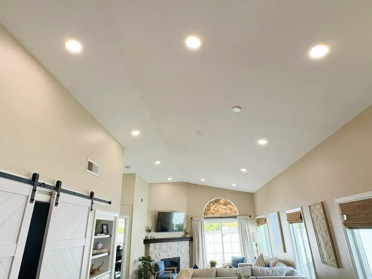 High ceiling living room with recessed lighting and a fireplace.