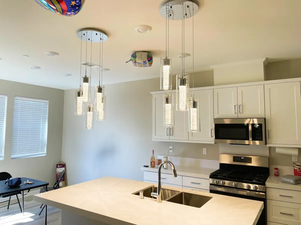 Ceiling with recessed lights, ceiling fan, and white kitchen cabinets.