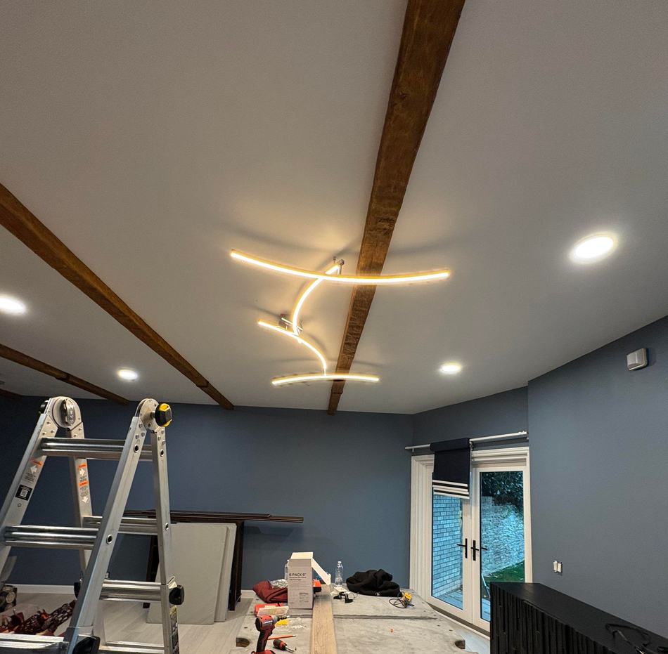 Wooden ceiling with hanging lights, a dining area, and a window with a blue view.