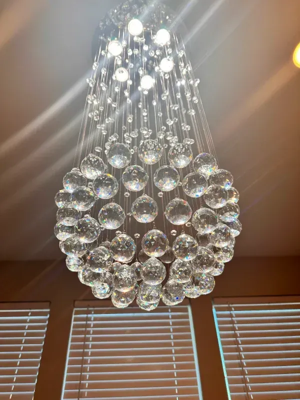 Crystal chandelier hanging from the ceiling, with multiple clear orbs and small lights.