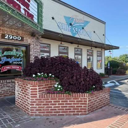 Restaurant exterior with red brick facade and planter; Gulf Seafood sign above.