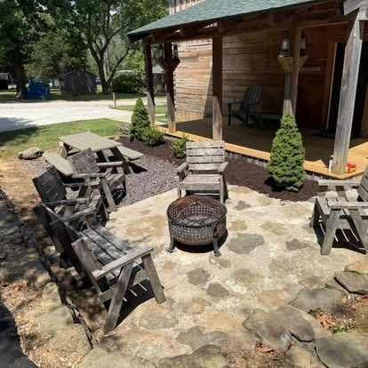 Outdoor cabin area with a fire pit, seating, and a picnic table.