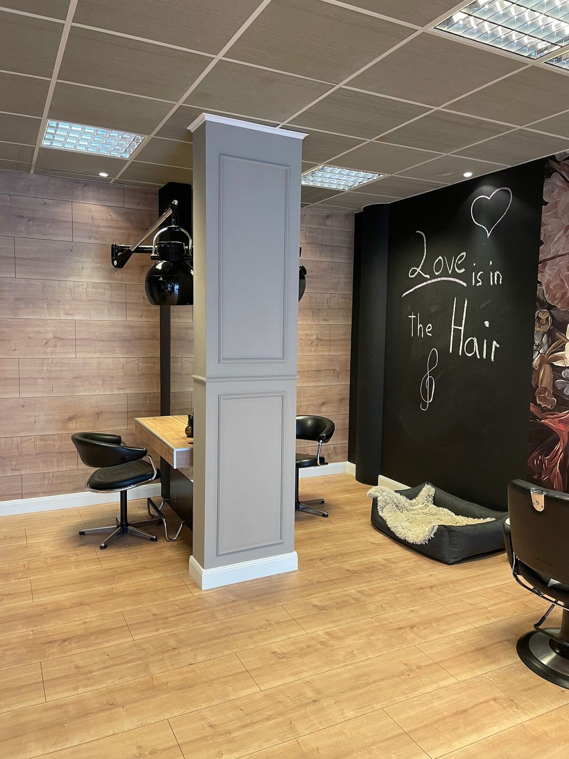 Ein Salon mit Holzboden, Stühlen und einer Säule.