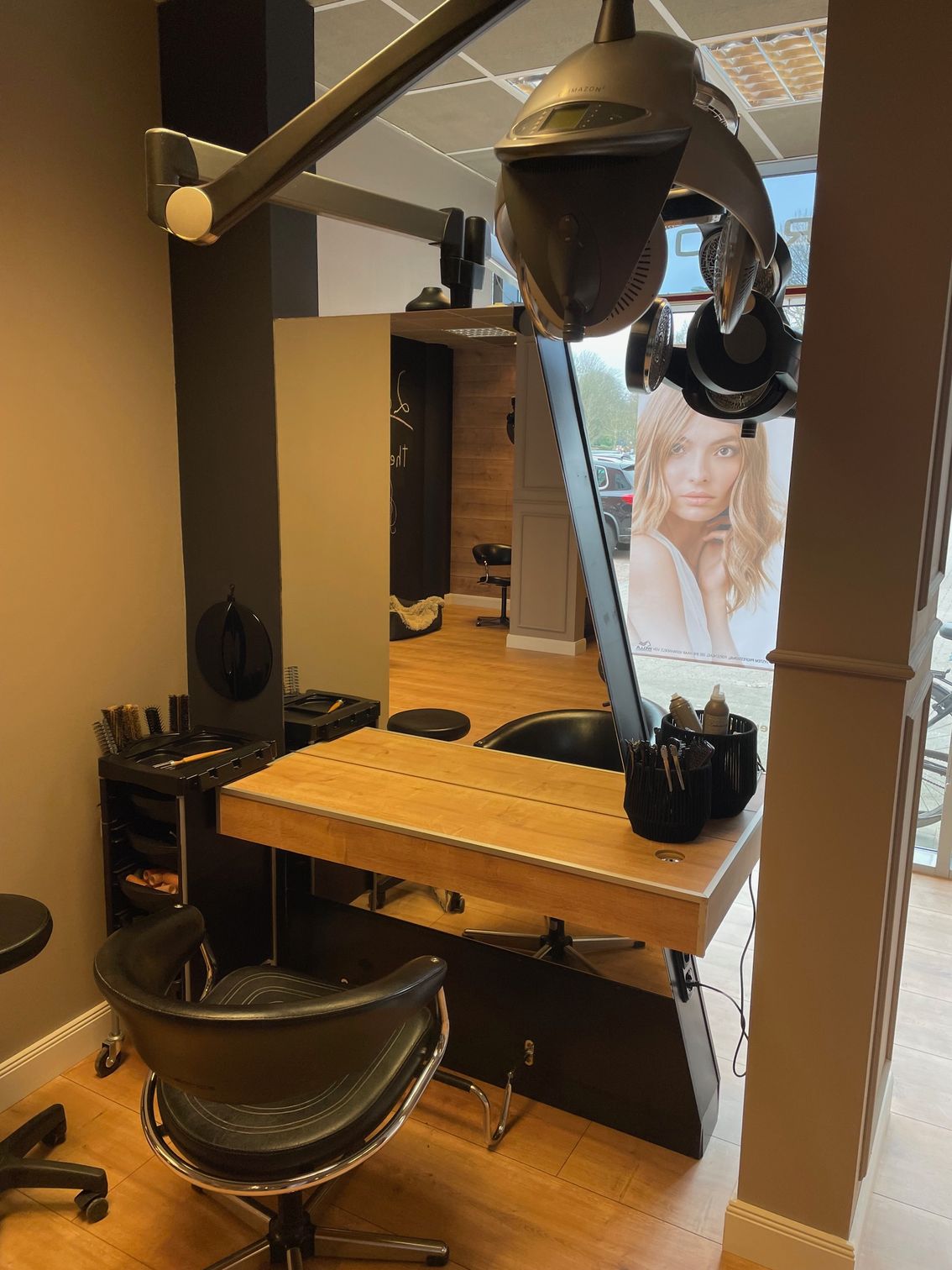 Ein Friseursalon mit einem Stuhl und einem Tisch mit einem Frauenbild an der Wand.