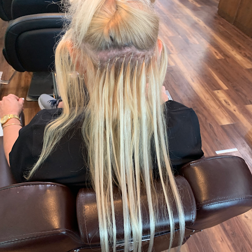 A woman with long blonde hair is sitting in a chair.