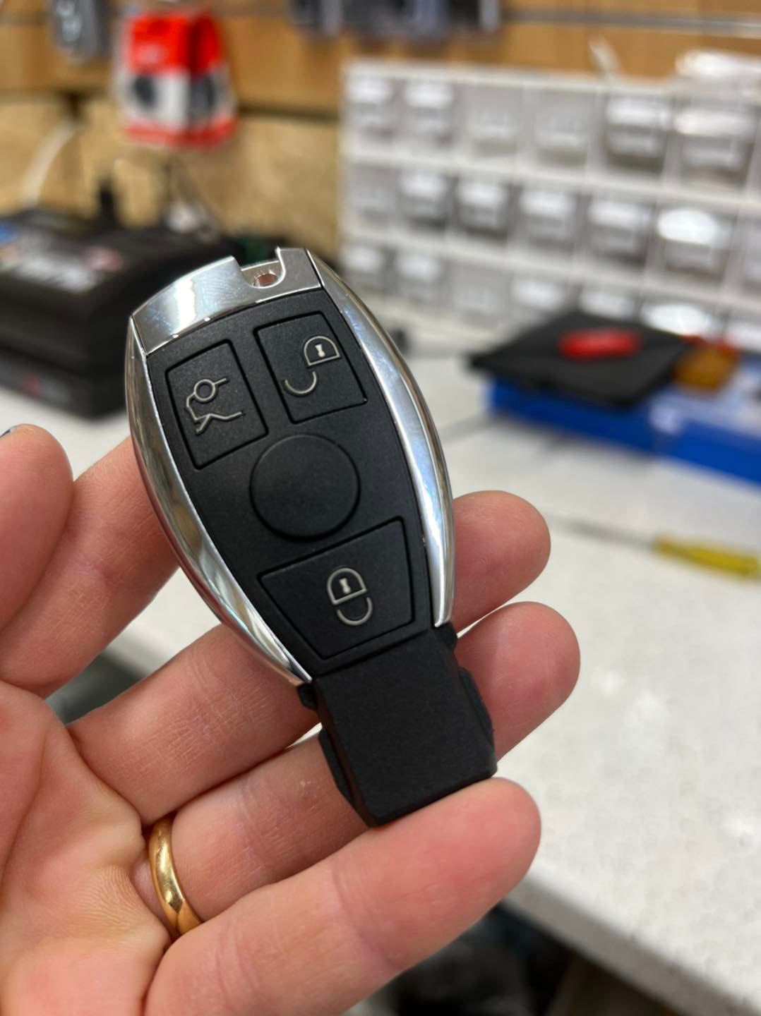 A Person Is Holding A Mercedes Key Fob In Their Hand — Port Macquarie Locksmiths In Port Macquarie, NSW