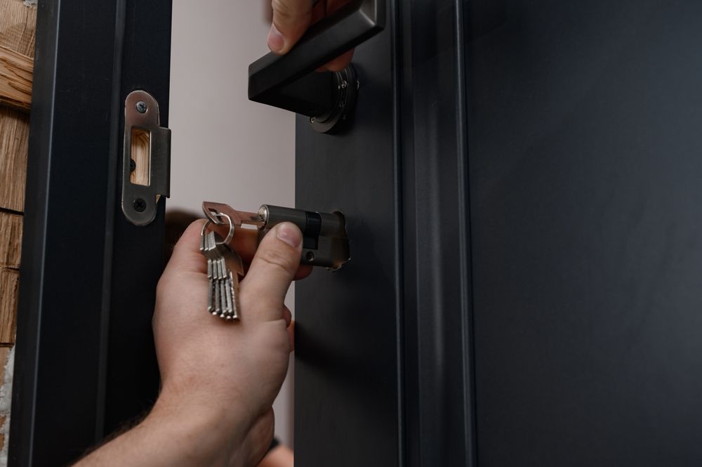 Hands Removing Cylinder Lock From Black Door Handle