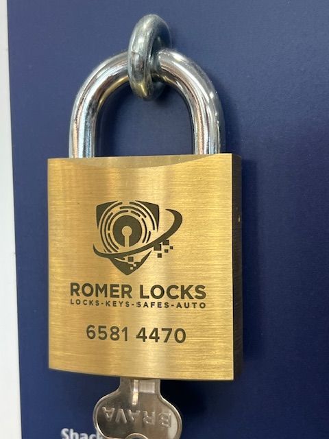 A Gold Padlock From Romer Locks With A Key — Port Macquarie Locksmiths In Port Macquarie, NSW