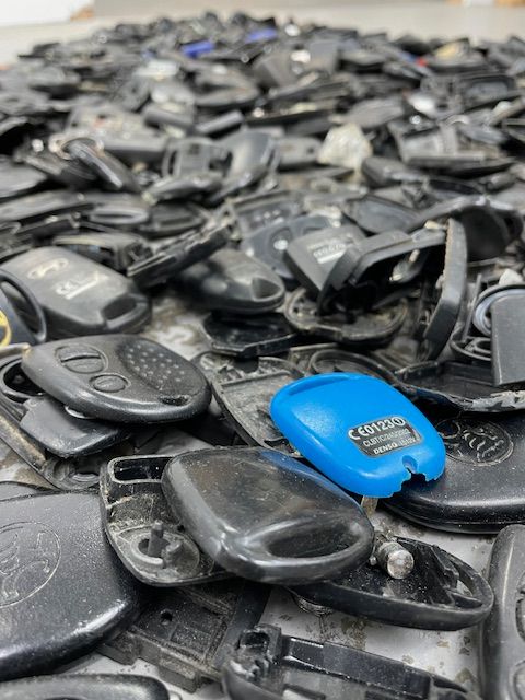 A Pile Of Car Keys With A Blue One In The Middle — Port Macquarie Locksmiths In Port Macquarie, NSW