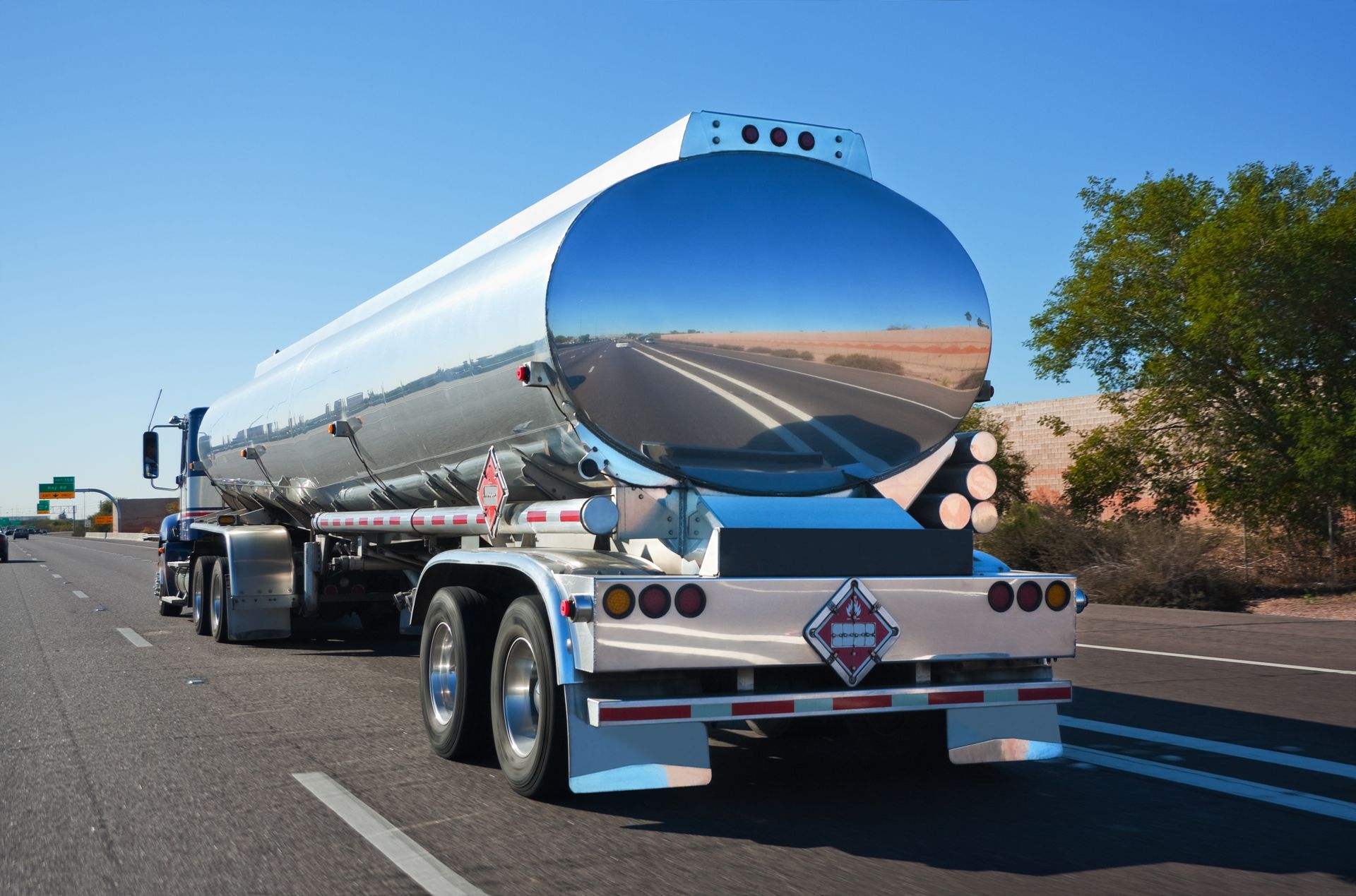 A tanker truck is driving down a highway.