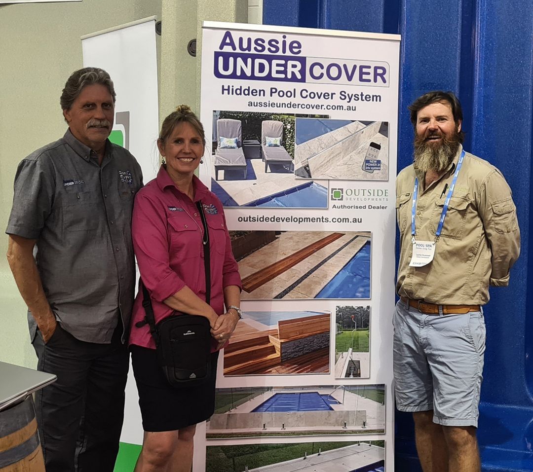 Three People Are Standing In Front Of A Sign That Says Aussie Under Cover — Aussie UnderCover In  Adelaide, SA