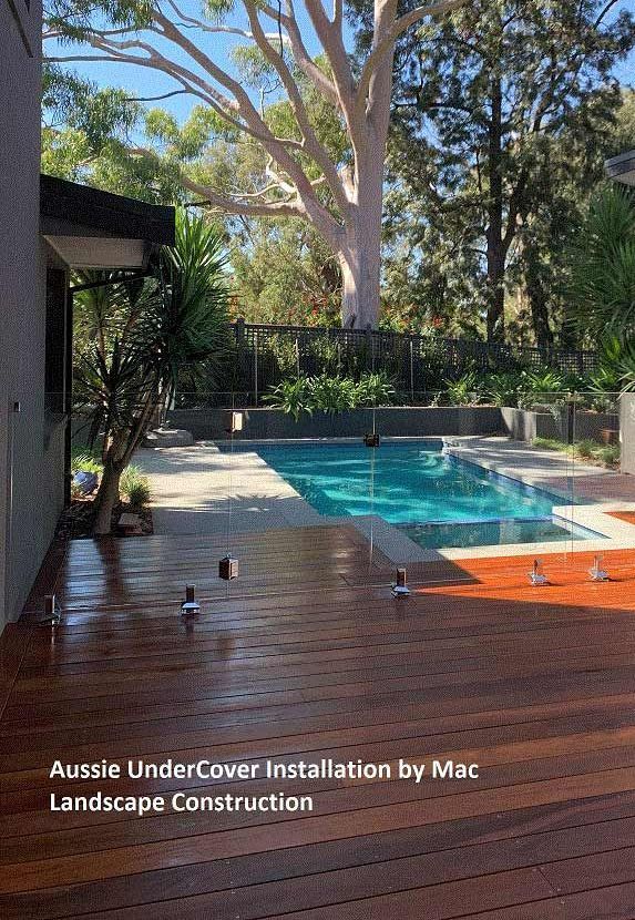 A Large Swimming Pool Is Surrounded By Trees And A Wooden Deck — Aussie UnderCover In South Nowra, NSW