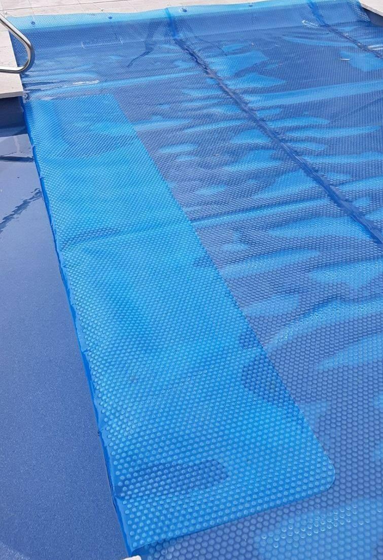 A Blue Pool Cover is Sitting on Top of a Swimming Pool — Aussie UnderCover In South Nowra, NSW
