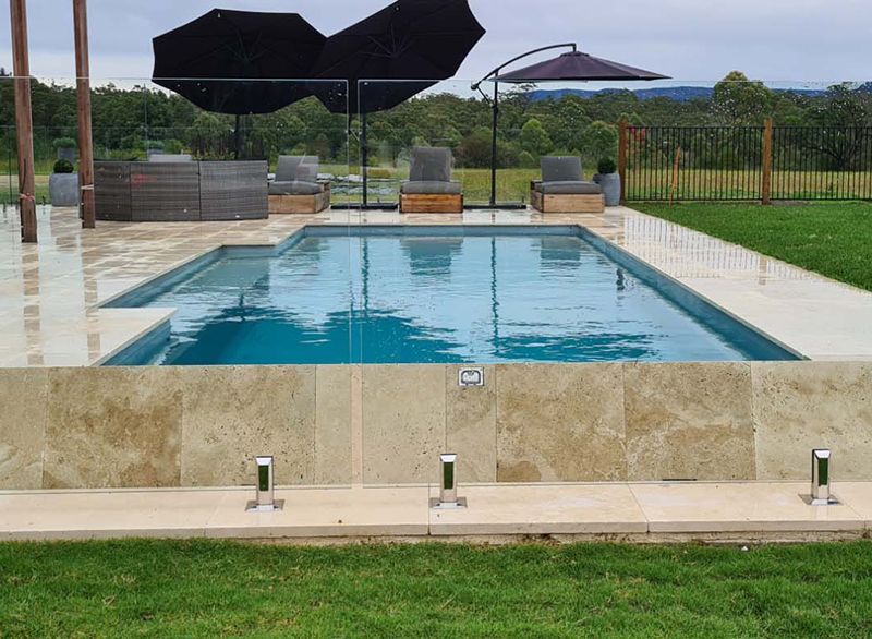 A Large Swimming Pool With Umbrellas And Chairs Around It — Aussie UnderCover In Mornington Peninsula, VIC