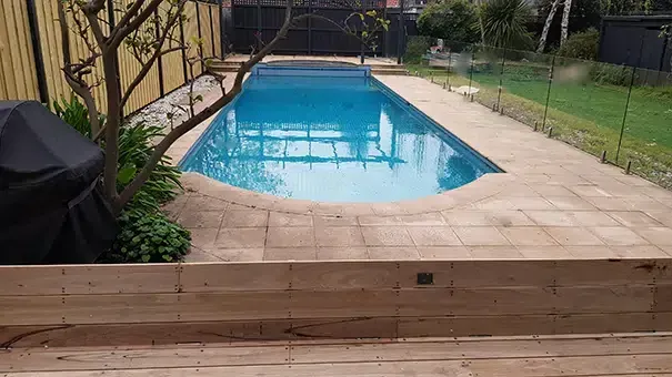 A Large Swimming Pool Surrounded By A Wooden Deck In A Backyard — Aussie UnderCover In Wollongong, NSW