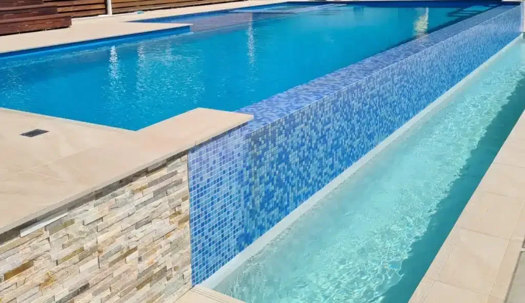 A Large Swimming Pool With Blue Tiles On The Side Of It — Aussie UnderCover In South Nowra, NSW