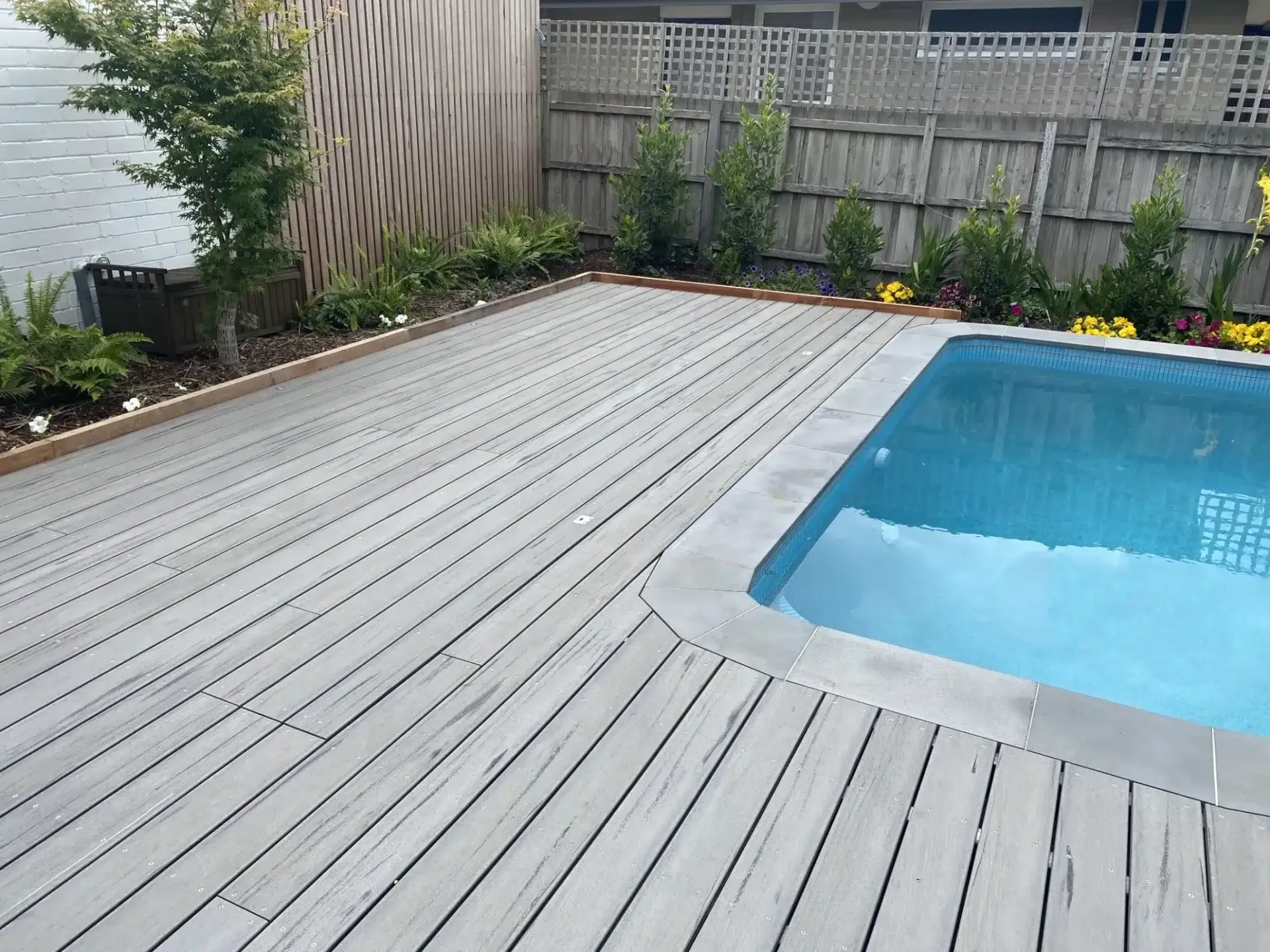 A Large Swimming Pool Is Surrounded By A Wooden Deck — Aussie UnderCover In South Nowra, NSW