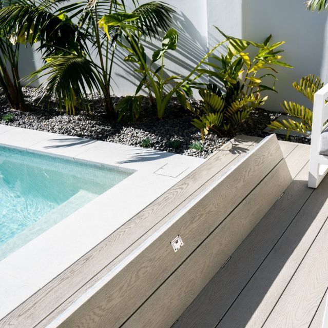 A Swimming Pool With a Wooden Deck Next to It — Aussie UnderCover In South Nowra, NSW