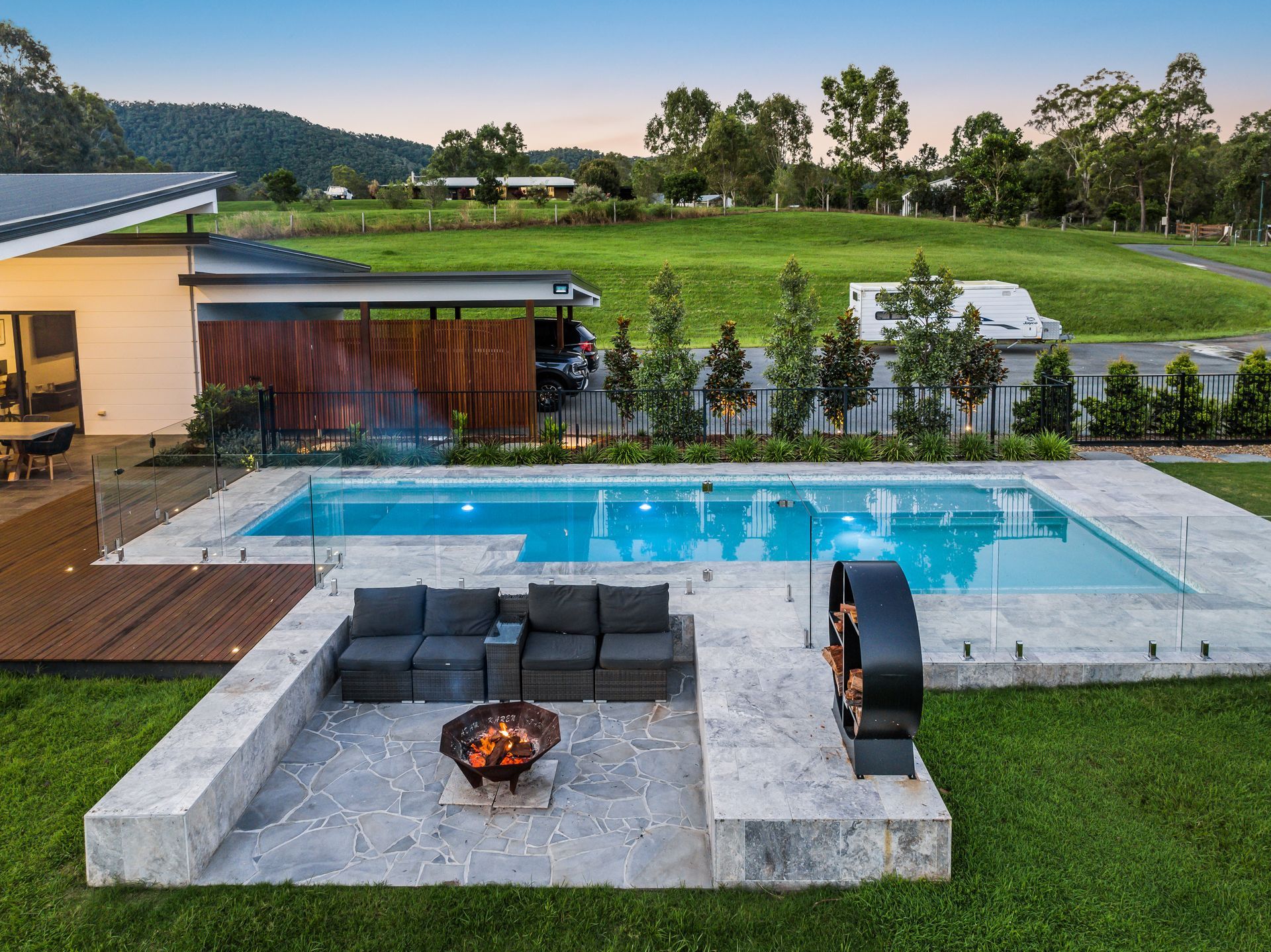 Modern home with pool, fire pit, and outdoor seating area in a grassy setting — Aussie UnderCover In  Adelaide, SA