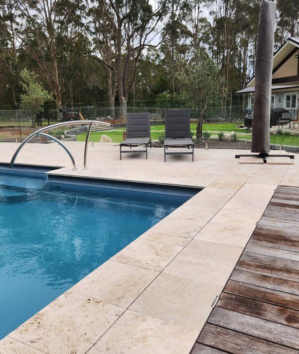 A swimming pool surrounded by chairs and an umbrella — Aussie UnderCover In South Nowra, NSW
