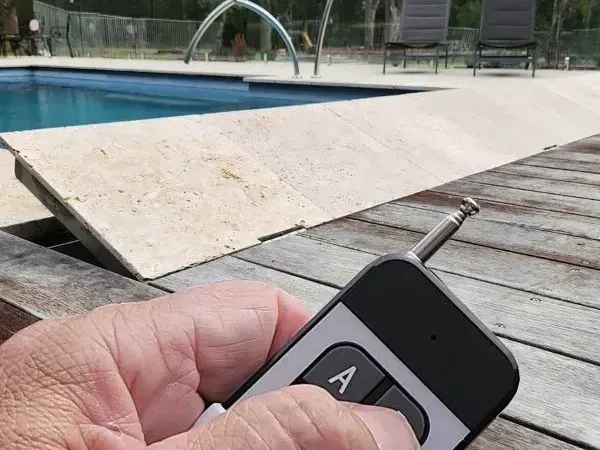Person's Hand Holding a Remote Control Near a Pool — Aussie UnderCover In Sydney, NSW