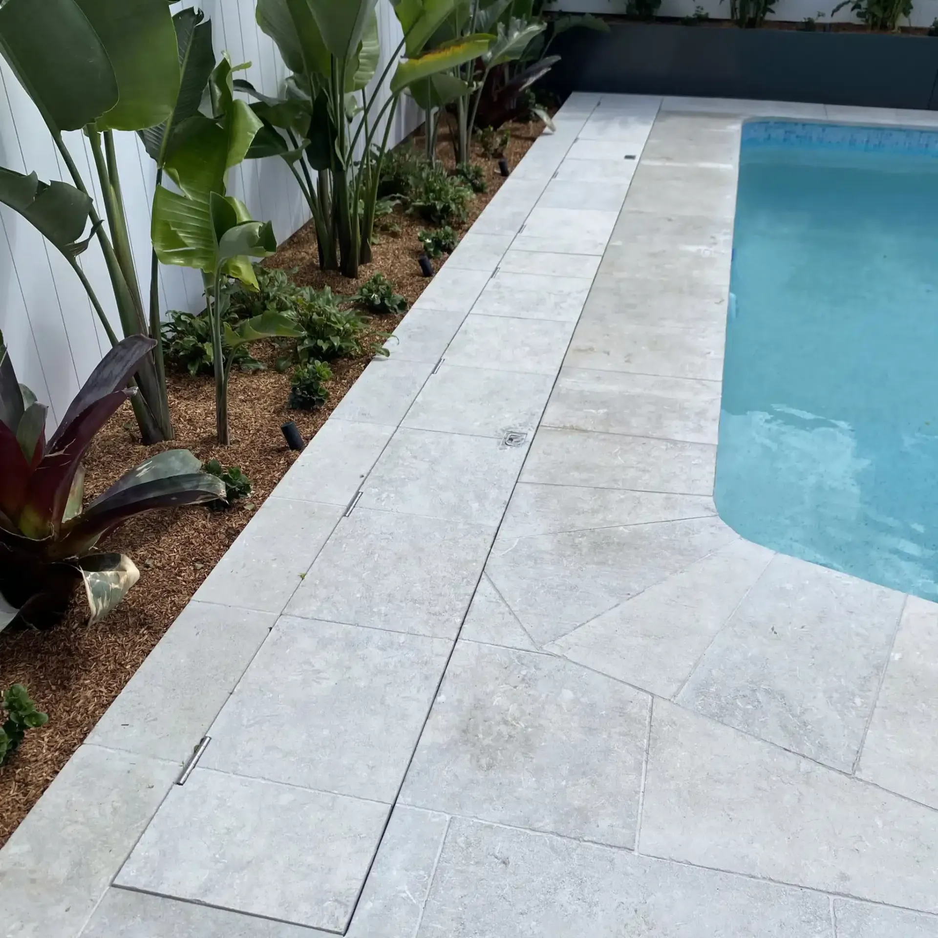 A Swimming Pool Is Surrounded By Plants And Tiles — Aussie UnderCover In South Nowra, NSW