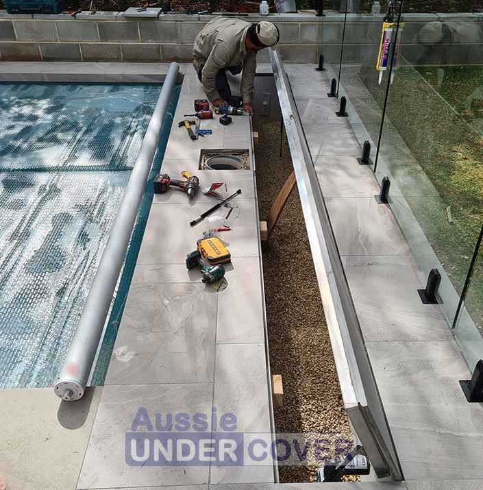 A Man Is Working On A Swimming Pool With A Sign That Says Aussie Under Cover — Aussie UnderCover In South Nowra, NSW