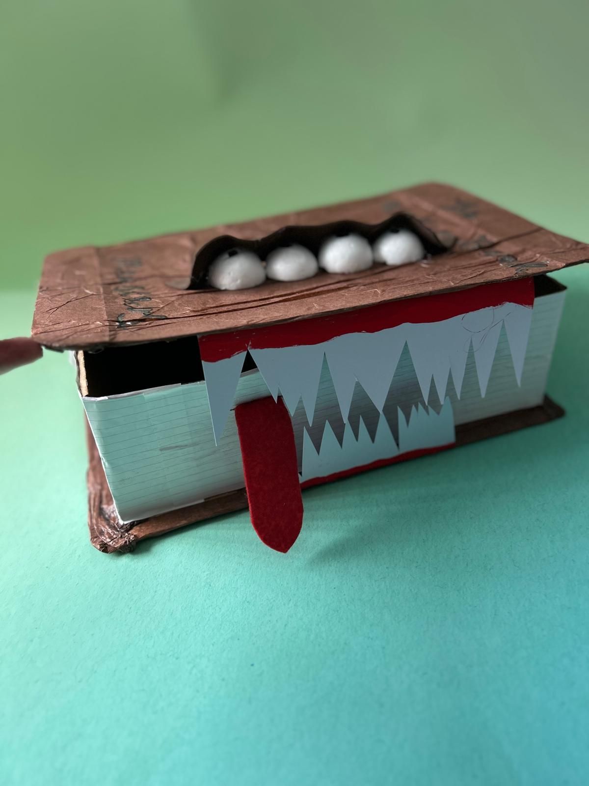 A cardboard box with teeth and a tongue sticking out of it for Dragonfly crafts party
