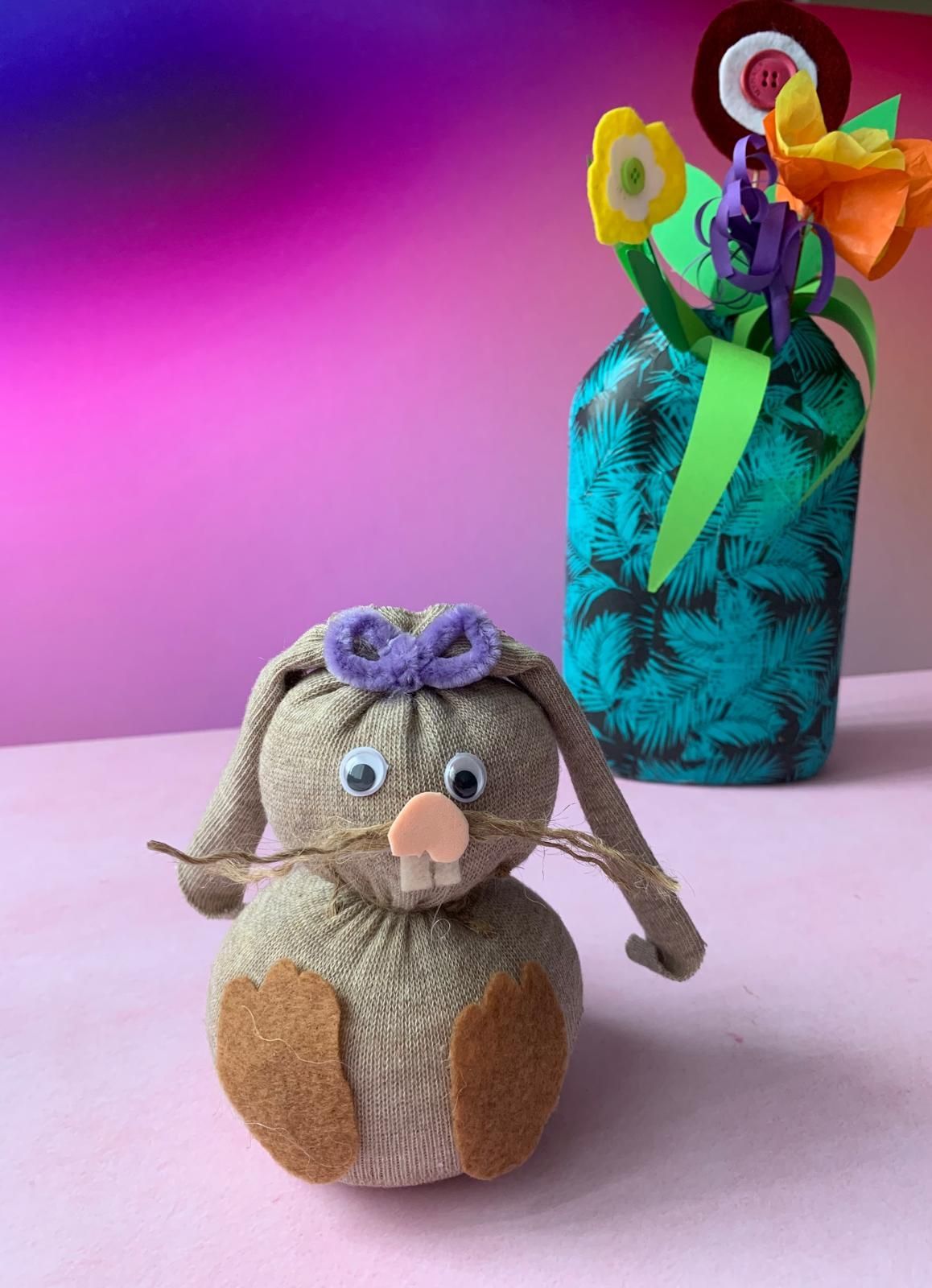 A stuffed bunny is sitting next to a vase of flowers for Dragonfly craft parties