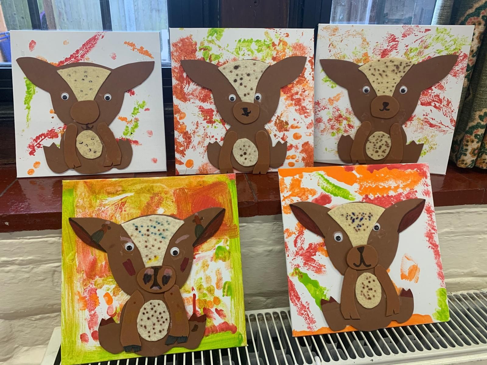 A bunch of paintings of a dog on a window sill at craft party