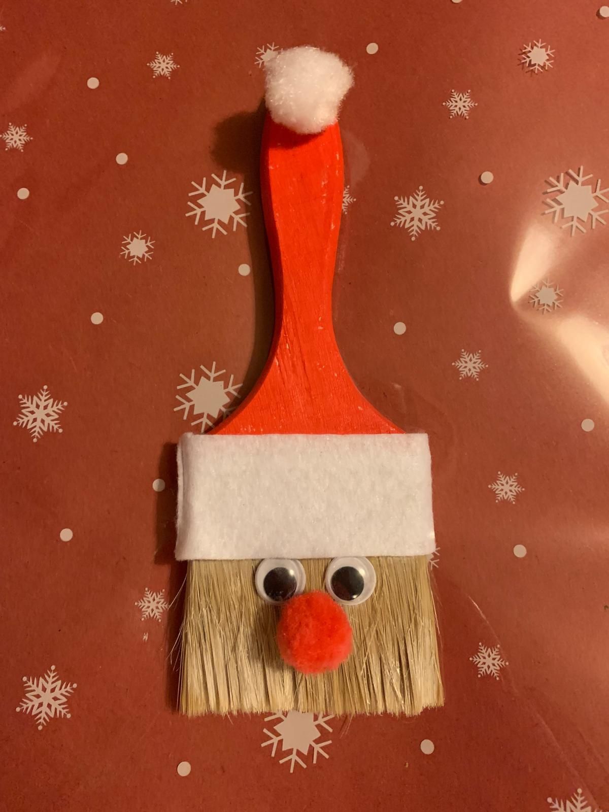 A brush with googly eyes and a santa hat on it for Dragonfly crafts party