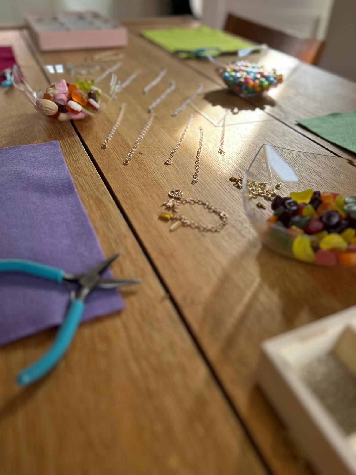 A wooden table with a lot of beads on it for charm party at Dragonfly crafts parties