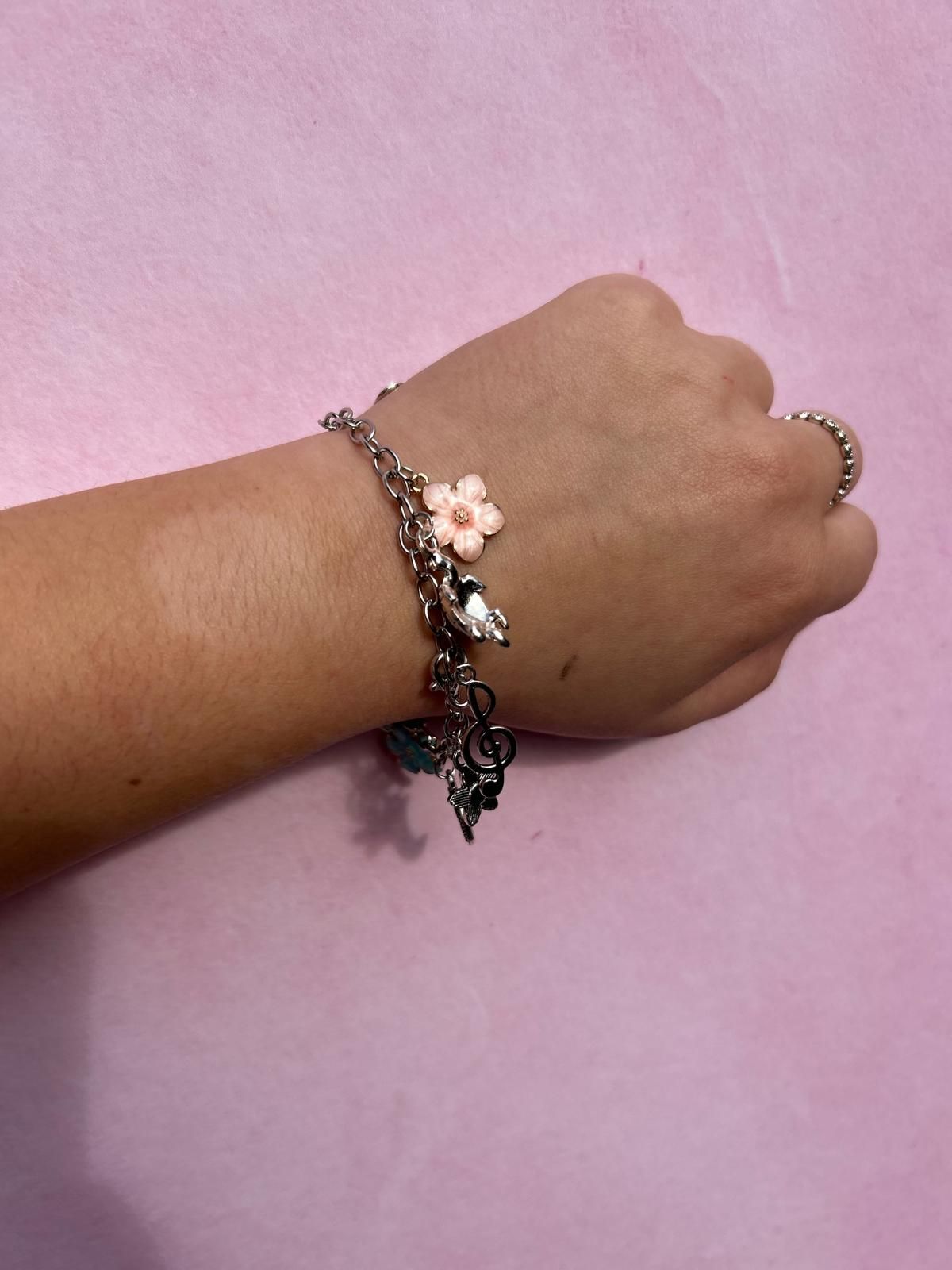 A woman wearing a bracelet with a pink flower on it for charm party at Dragonfly crafts parties