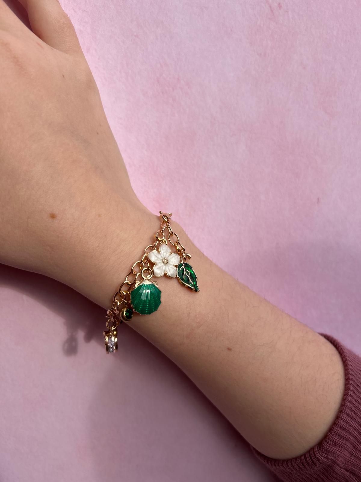 A person wearing a bracelet with green beads and a white flower for charm party at Dragonfly crafts parties