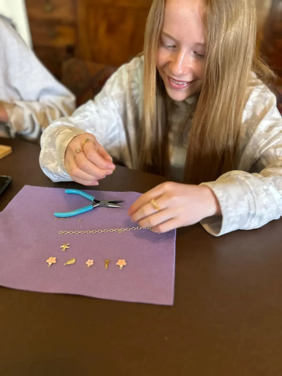 A wooden table with a lot of beads on it for charm party at Dragonfly crafts parties