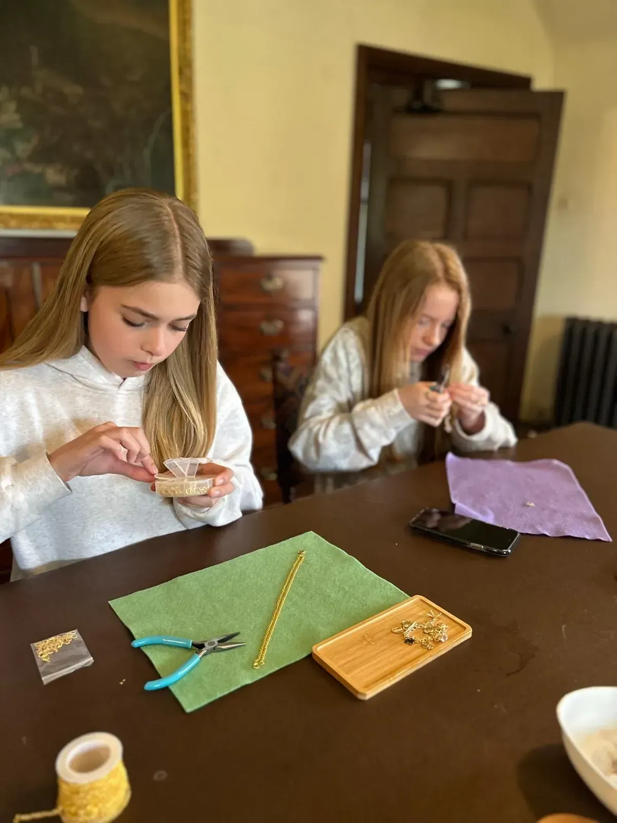 A pink jewelry box with a clear lid filled with jewellery for charm party at Dragonfly crafts parties