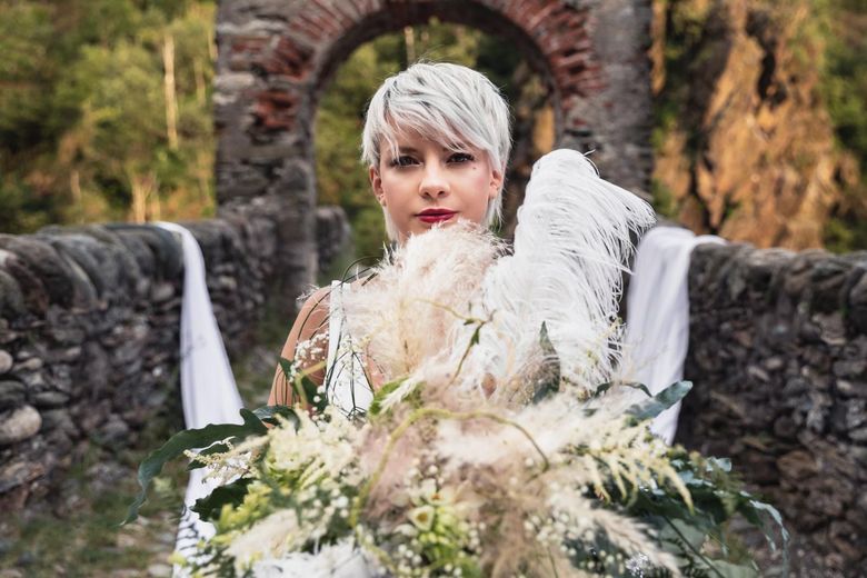 Una donna indossa un vestito rosso fatto di fiori