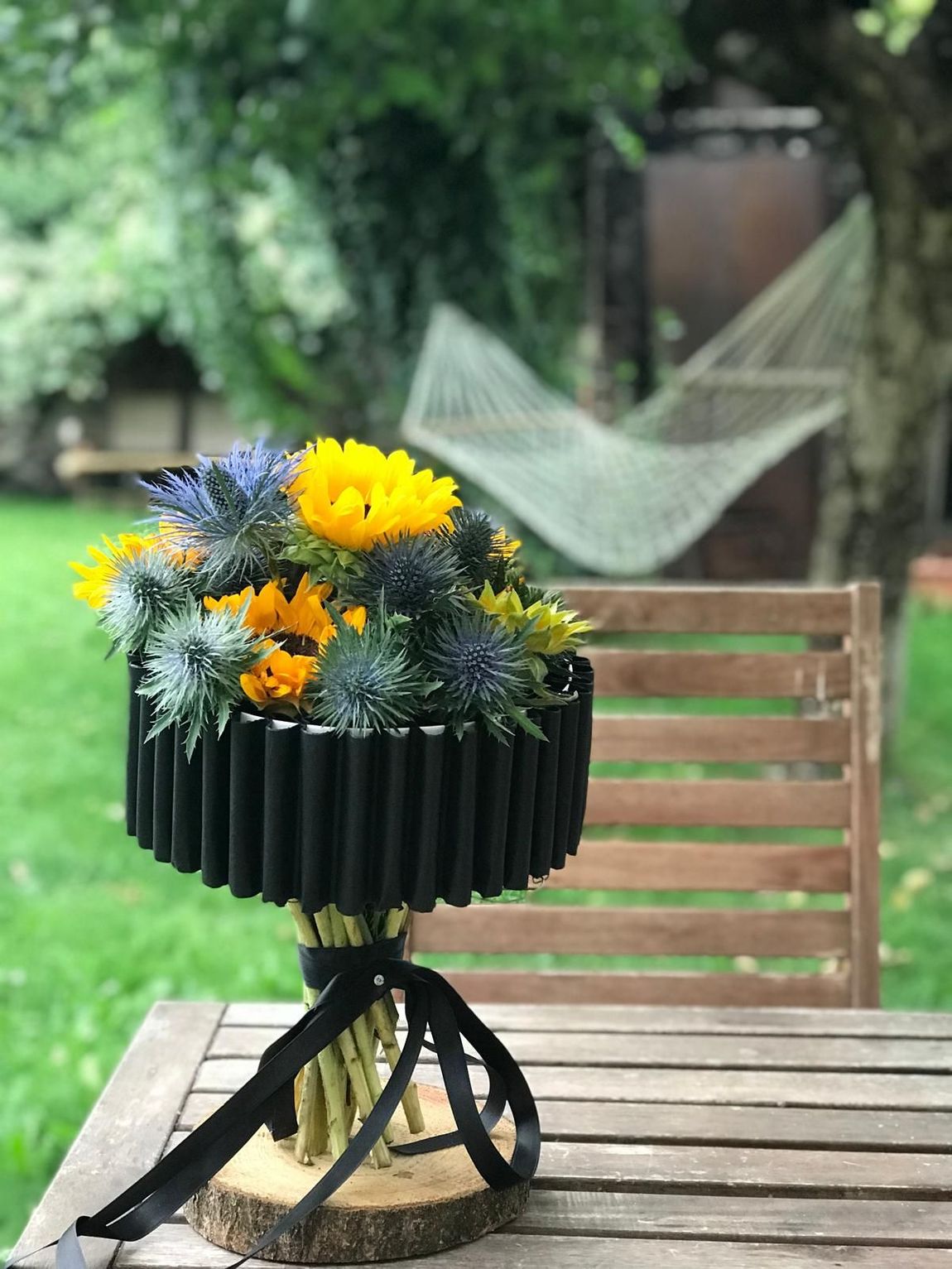 Un mazzo di fiori è appoggiato su un tavolo di legno.