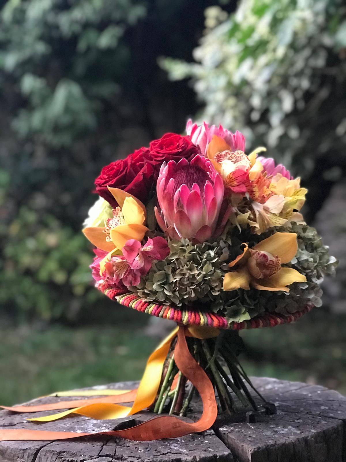 Un mazzo di fiori è appoggiato su un ceppo di legno.