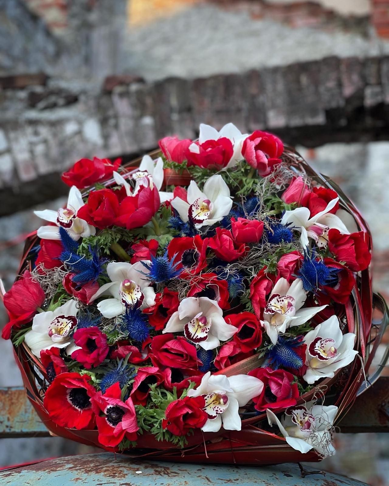 Un mazzo di fiori rossi, bianchi e blu in un cestino