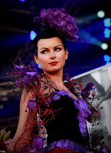 A woman wearing a purple dress and a purple flower in her hair