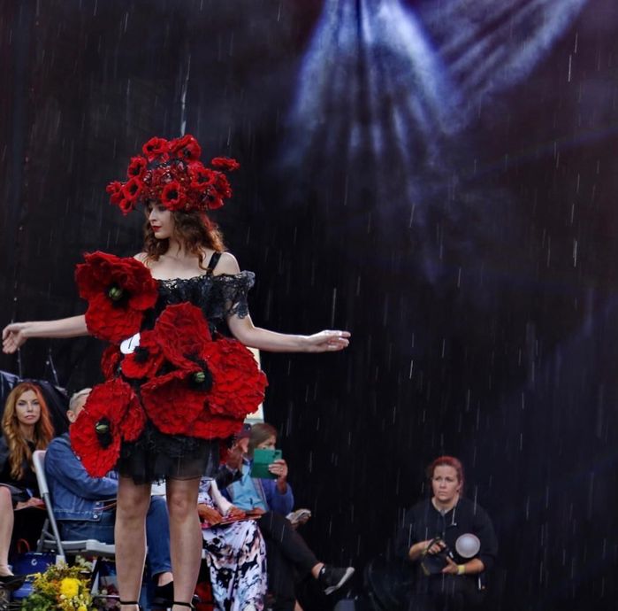 A woman in a black dress with red flowers in her hair.