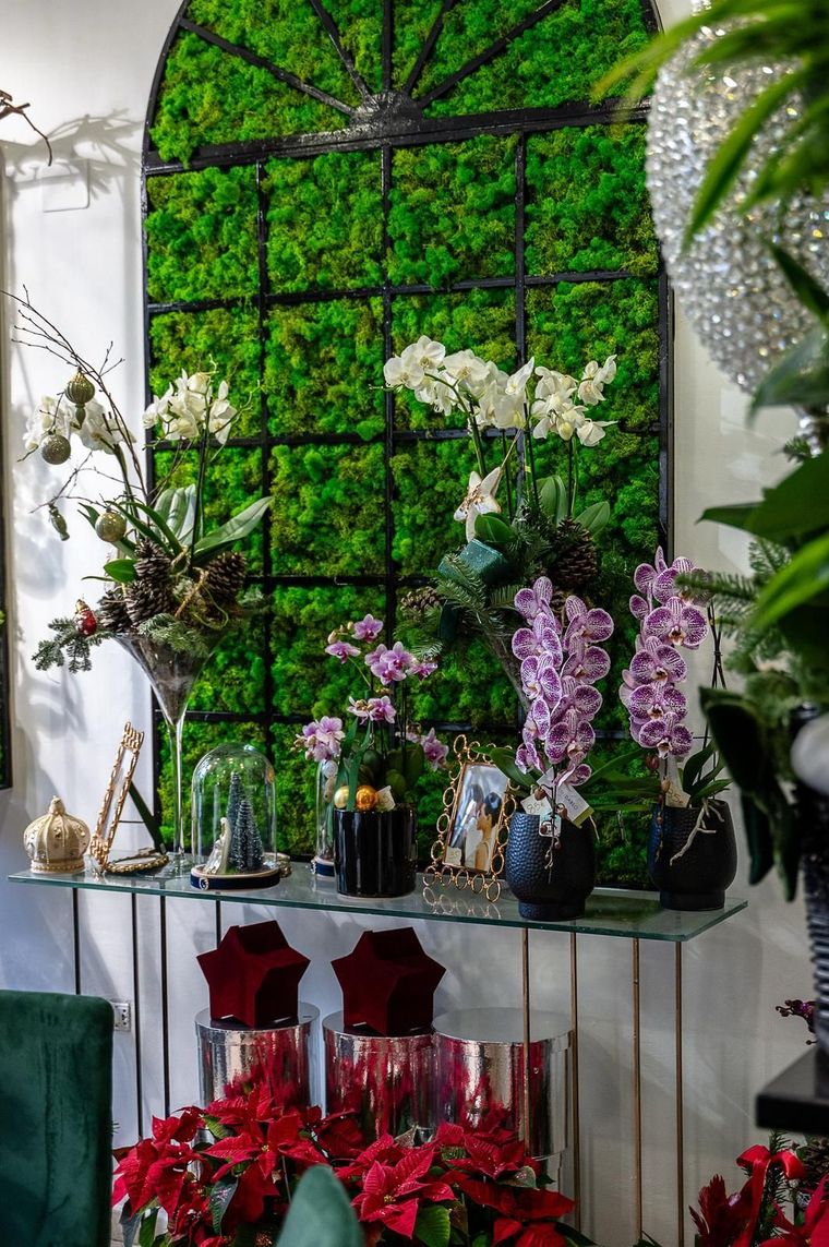 Una stanza piena di fiori e una parete verde.